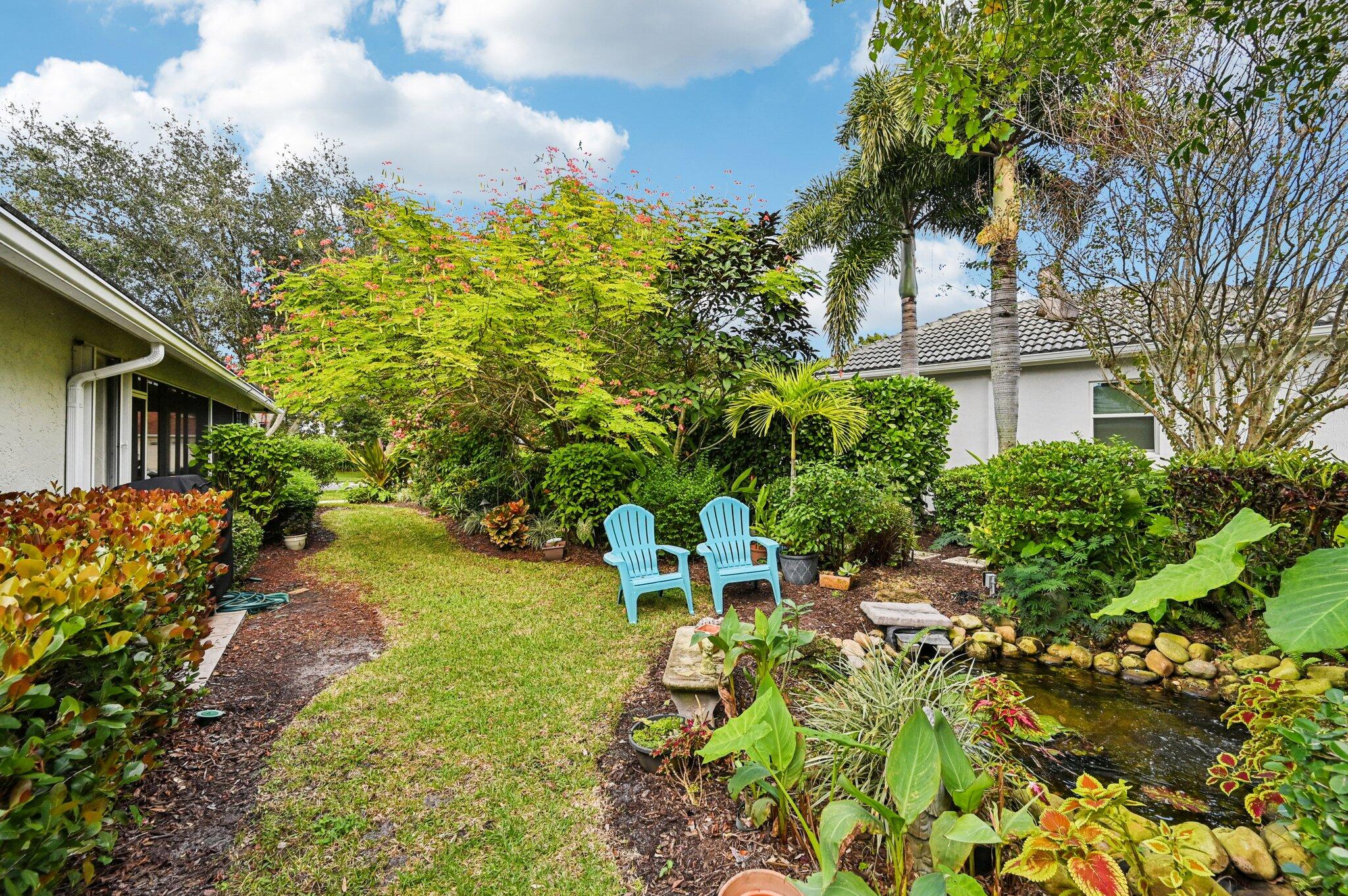 231 Sparrow Point Jupiter, FL 33458 - Photo 37 of 65 a backyard of a house with a garden and outdoor seating