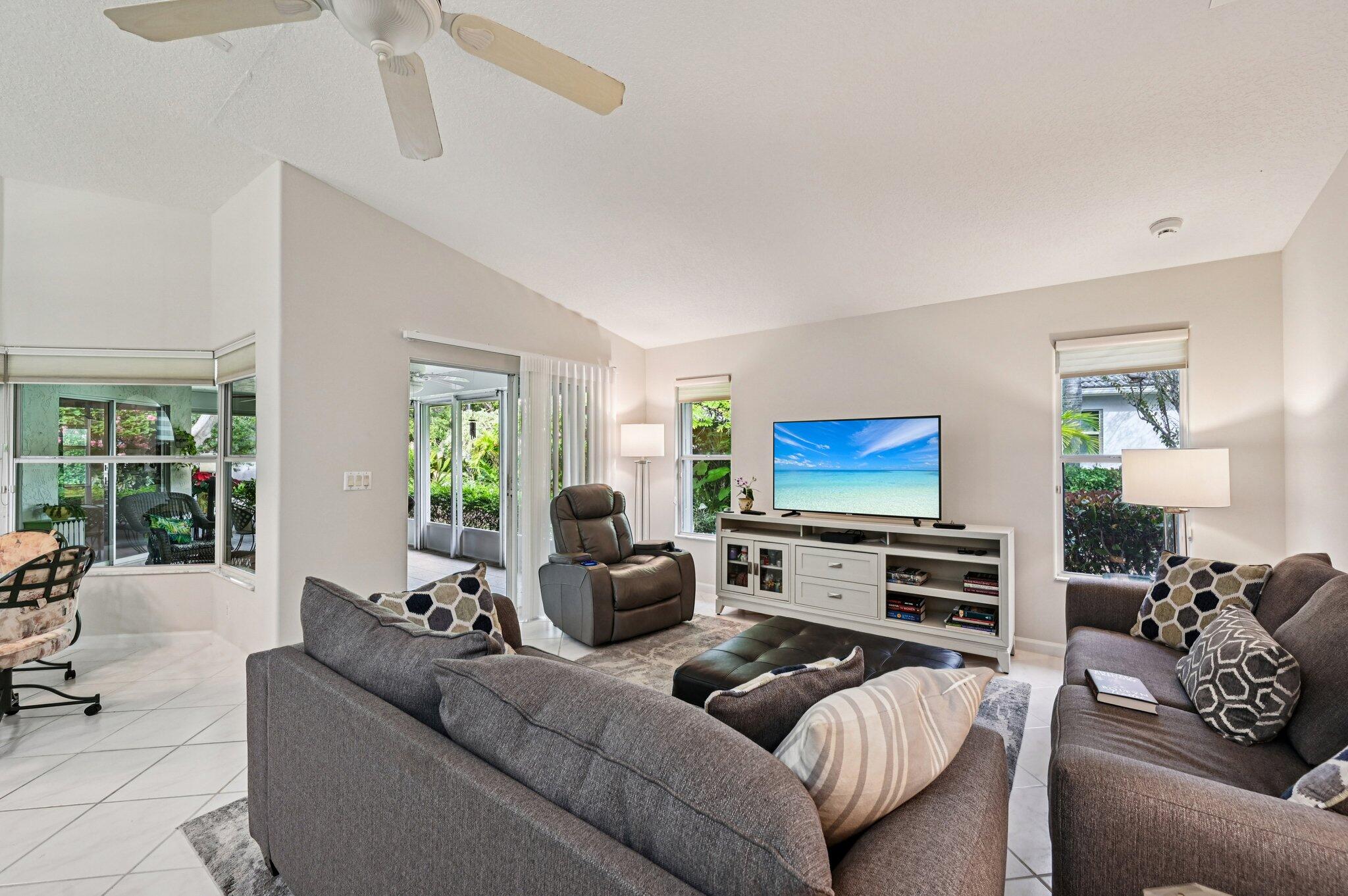 231 Sparrow Point Jupiter, FL 33458 - Photo 9 of 65 a living room with furniture a flat screen tv and a large window