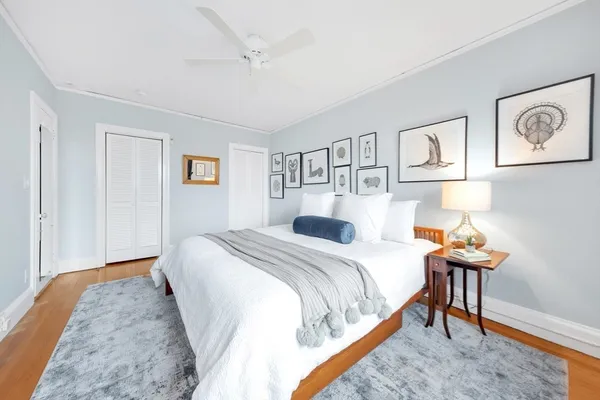 a bedroom with a bed and wooden floor