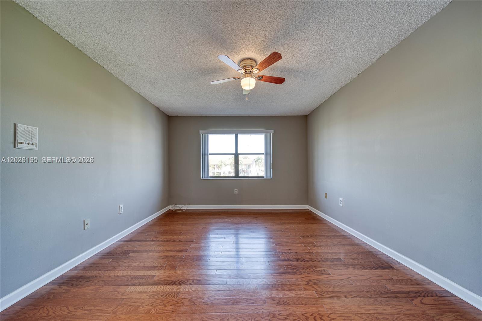 13337 Southwest 64th Lane Miami, FL 33183 - Photo 22 of 36 a view of an empty room with window and wooden floor