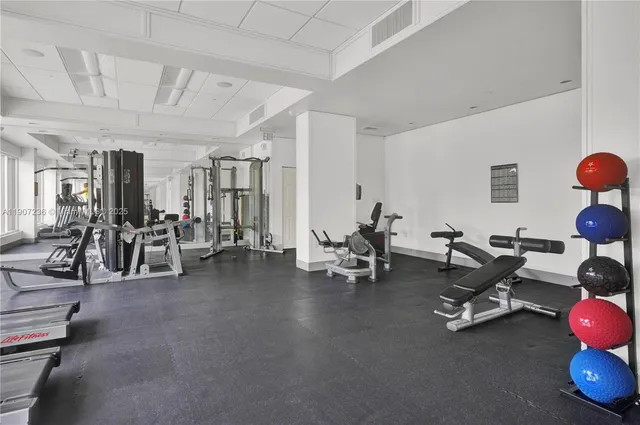 a view of a room with gym equipment and large windows