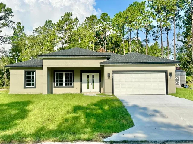 a front view of a house with a garden and yard