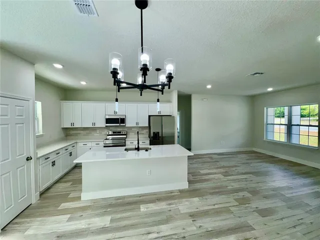 a view of a kitchen with center island and stainless steel appliances