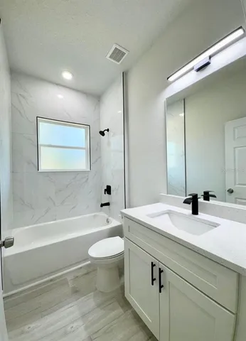 a bathroom with a sink a toilet and bathtub
