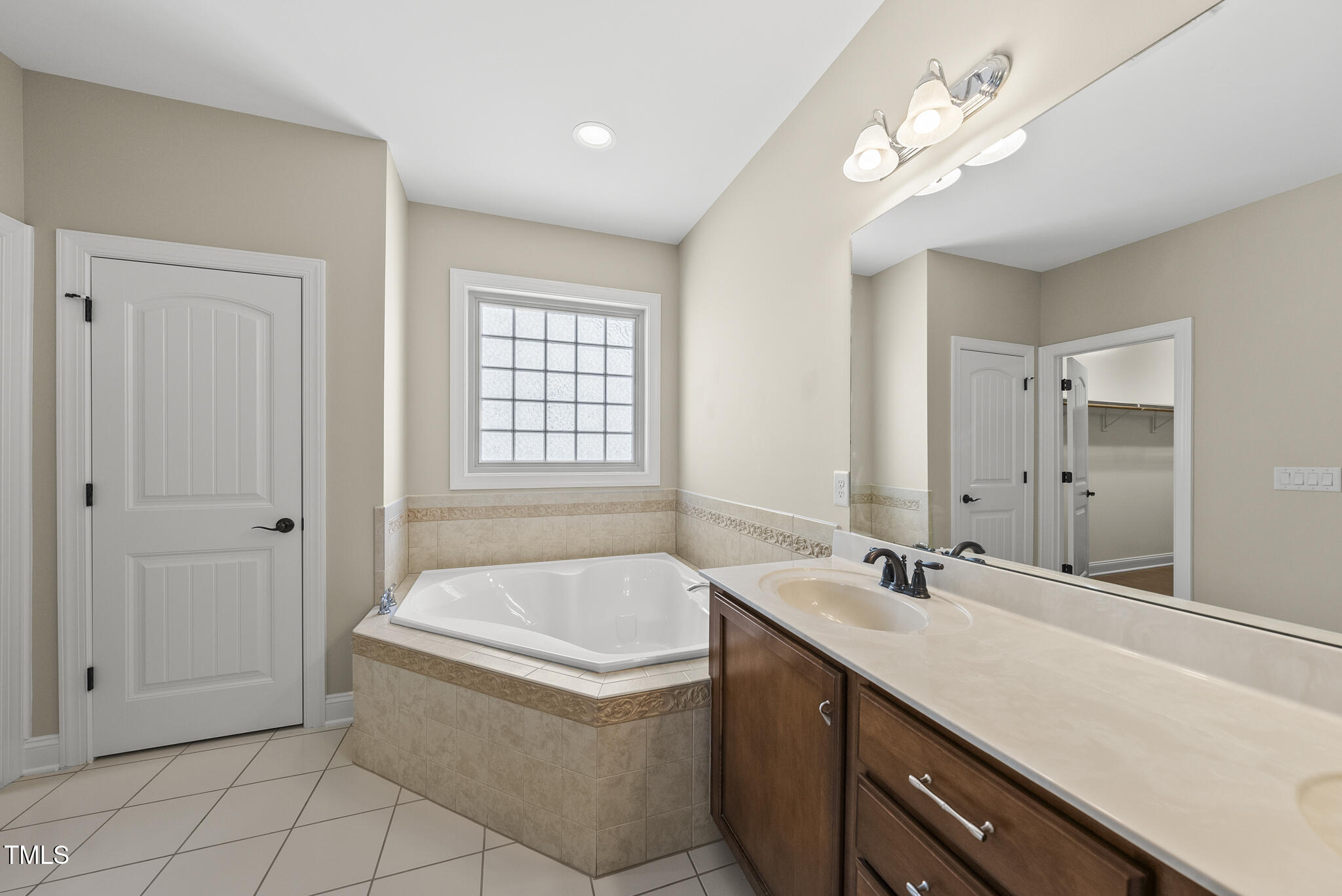 5120 Audreystone Drive Cary, NC 27518 - Photo 35 of 65 a bathroom with a tub a sink and mirror