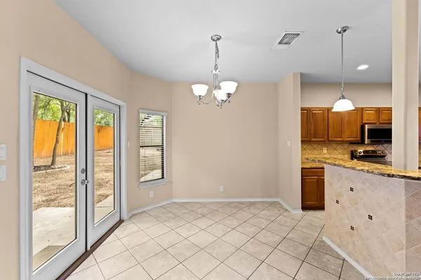 a view of a kitchen with a sink wooden cabinets and entryway