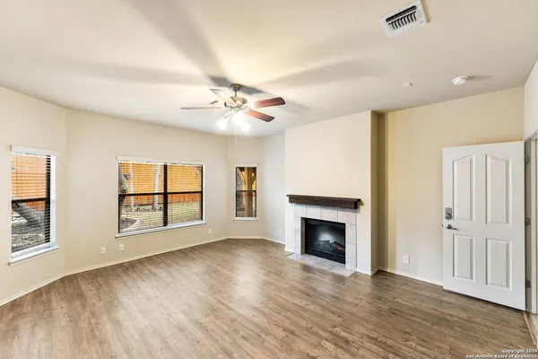 an empty room with windows and fireplace