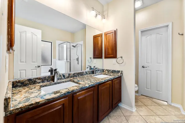 a bathroom with a granite countertop sink and a mirror