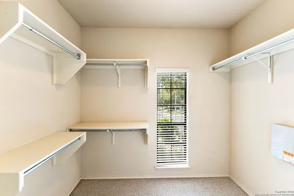a view of walk in closet with empty racks