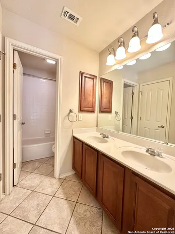 a spacious bathroom with a bathtub sink mirror and a shower