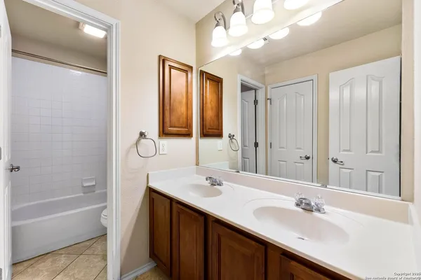 a bathroom with a tub a sink and mirror