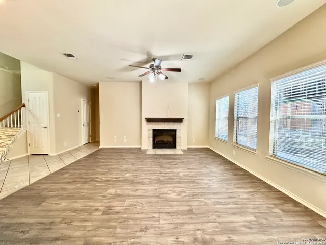 a view of an empty room with a fireplace and a window