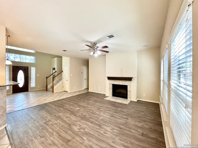 a view of empty room with wooden floor and fireplace