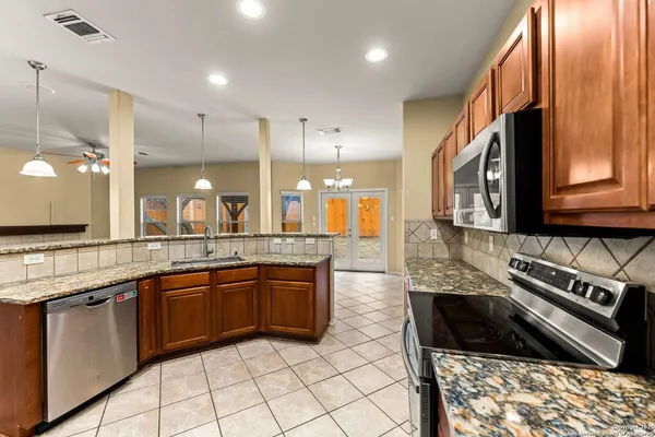 a kitchen with stainless steel appliances granite countertop a stove a sink and a microwave