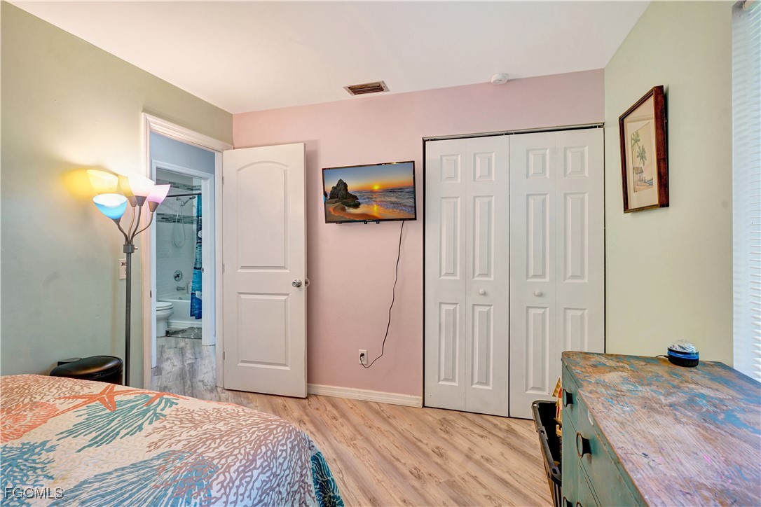 5887 Kingfish Road Bokeelia, FL 33922 - Photo 13 of 34 a bedroom with a bed and a chandelier