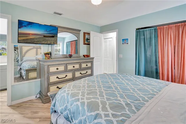 a bedroom with a bed and a dresser with mirror