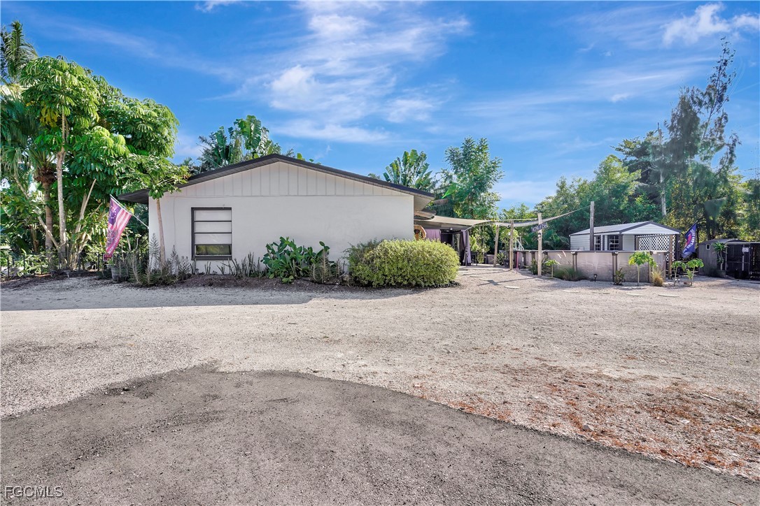5887 Kingfish Road Bokeelia, FL 33922 - Photo 27 of 34 a view of a house with backyard and bushes