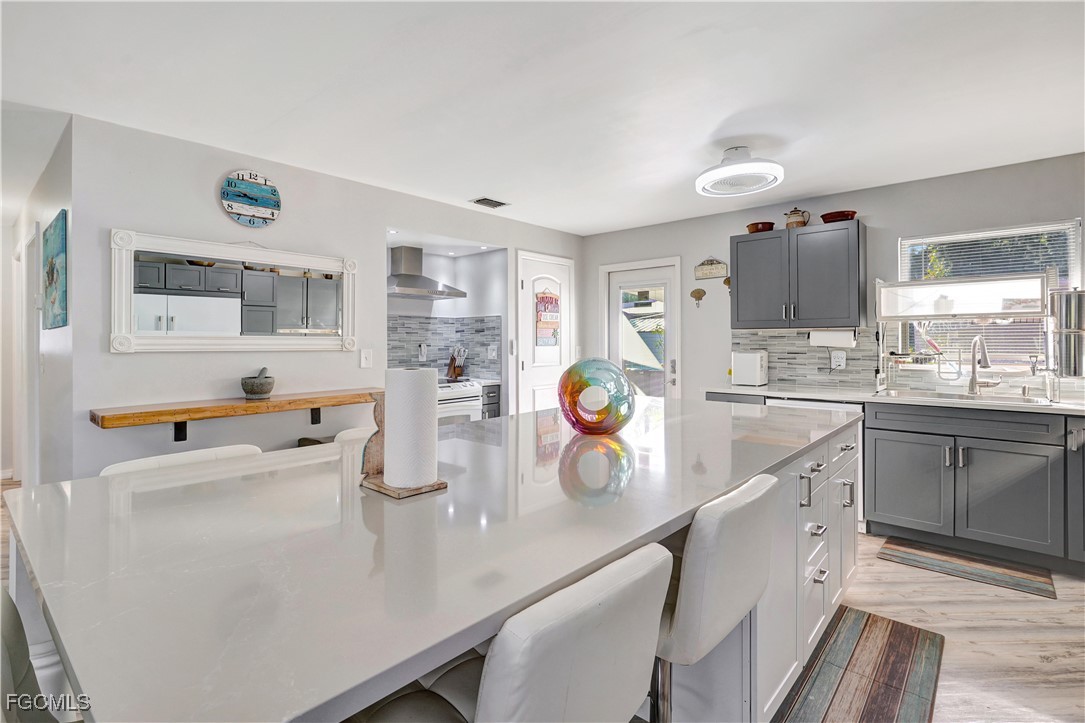 5887 Kingfish Road Bokeelia, FL 33922 - Photo 5 of 34 a kitchen with stainless steel appliances a sink a stove a refrigerator cabinets and a dining table