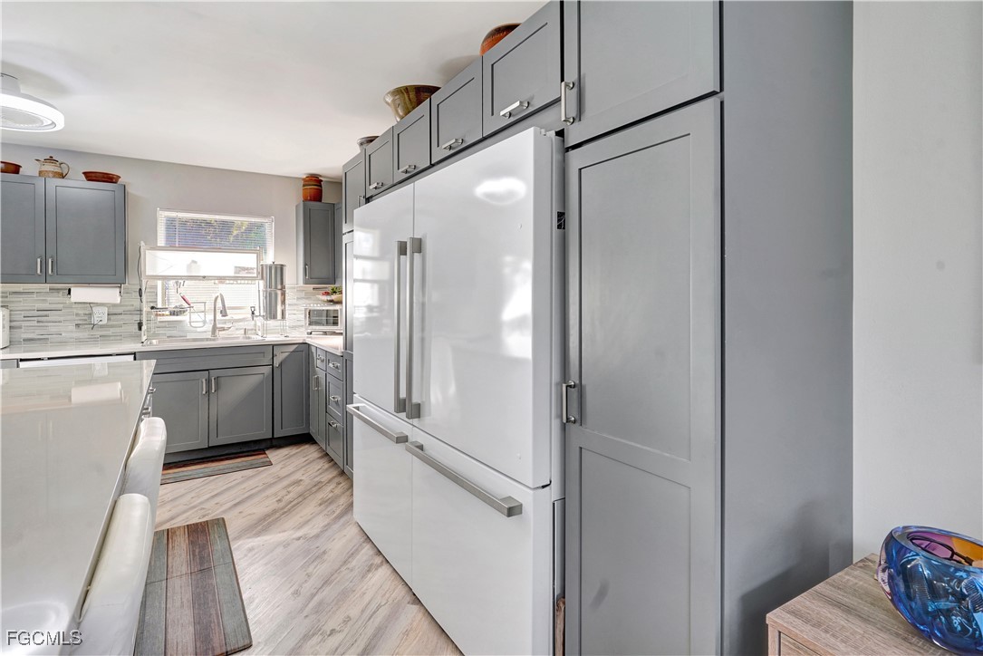 5887 Kingfish Road Bokeelia, FL 33922 - Photo 6 of 34 a kitchen with a sink a refrigerator and cabinets