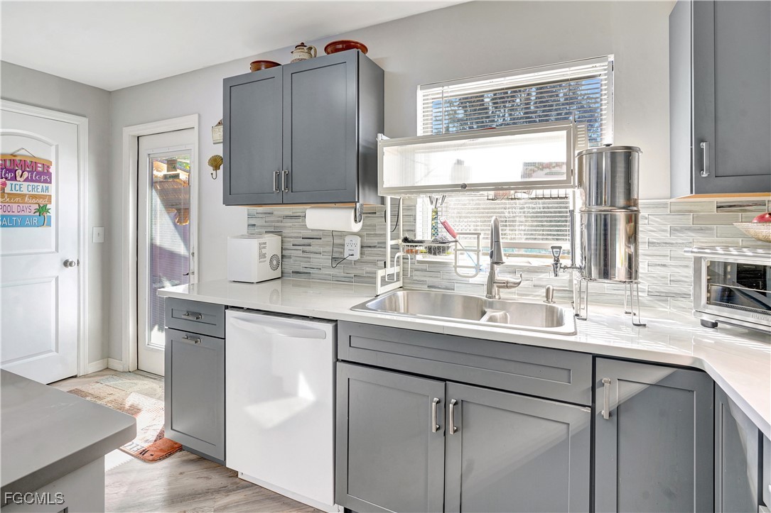 5887 Kingfish Road Bokeelia, FL 33922 - Photo 7 of 34 a kitchen with a sink window and cabinets