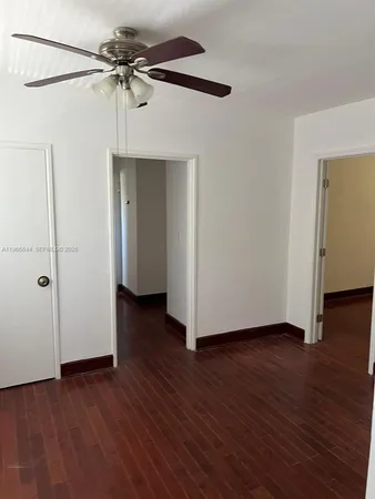 a view of a livingroom with wooden floor and a ceiling fan