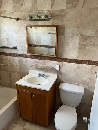 a bathroom with a toilet sink and mirror