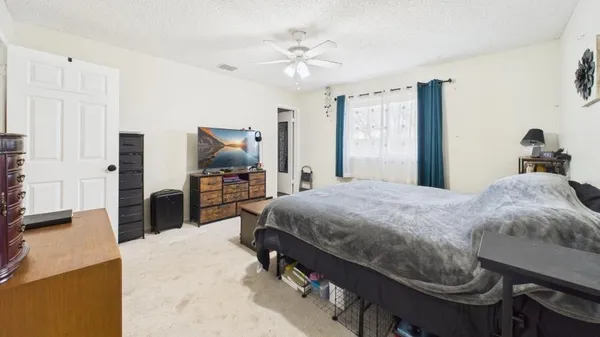 a bedroom with a bed and a flat tv screen on wall
