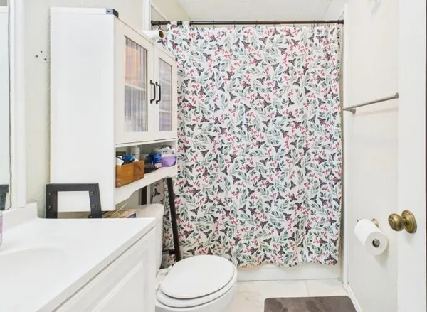 a bathroom with a toilet and a shower curtain
