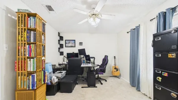 a view of a workspace with furniture and a window