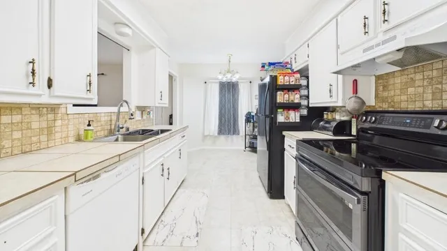 a kitchen with stainless steel appliances granite countertop a sink stove and cabinets