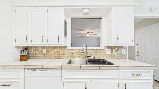a kitchen with cabinets and window