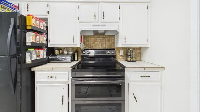 a stove top oven sitting inside of a kitchen