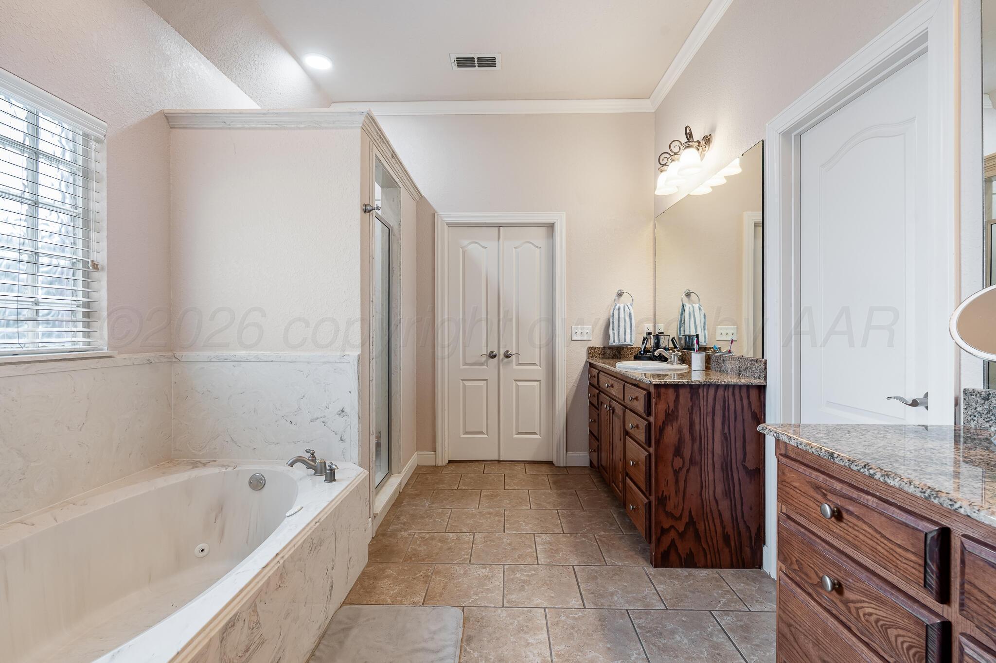 5008 Wesley Road Amarillo, TX 79119 - Photo 25 of 47 a bathroom with a tub sink and mirror