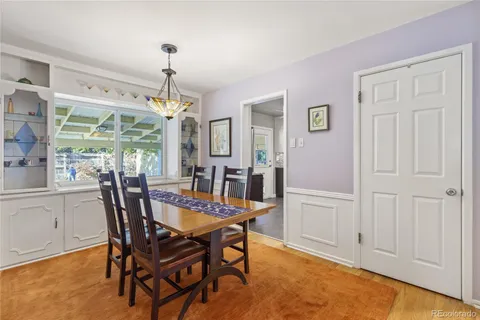 a dining room with furniture window and wooden floor
