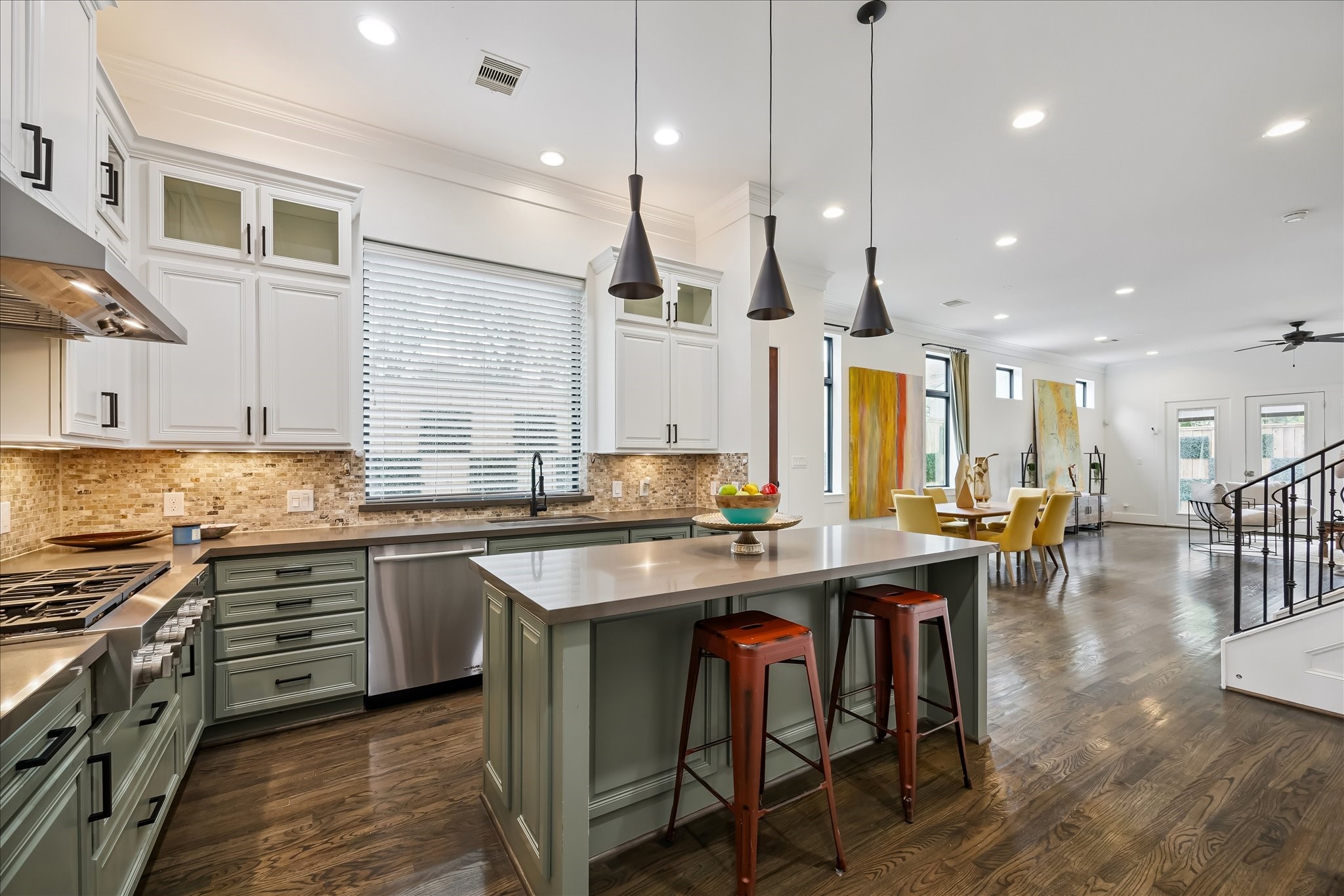 1208 Welch Street Houston, TX 77006 - Photo 2 of 35 The kitchen has large island perfect for meal prep and casually dining. Vibrant contrast between lower and upper cabinets, quartz counters, and neutral backsplash create a dynamic space.