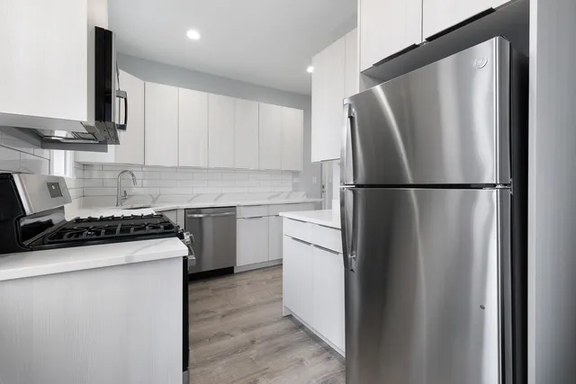 a kitchen with a refrigerator sink stove and cabinets