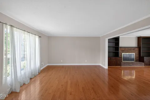 an empty room with windows and a fireplace