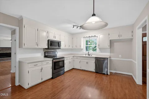 a kitchen with white cabinets appliances and sink