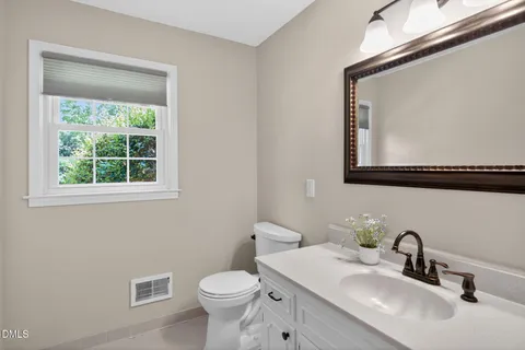 a kitchen with granite countertop a stove a sink dishwasher a refrigerator and white cabinets with wooden floor