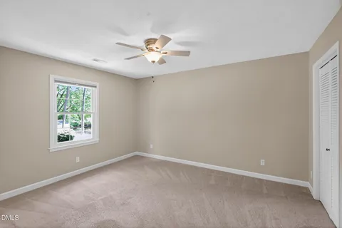a bathroom with a toilet sink a mirror and a window