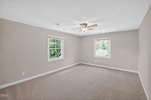 an empty room with a window and a fan