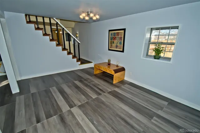 a living room with wooden floor and stairs