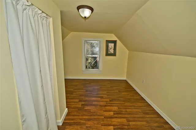 a view of a room with wooden floor and entrance