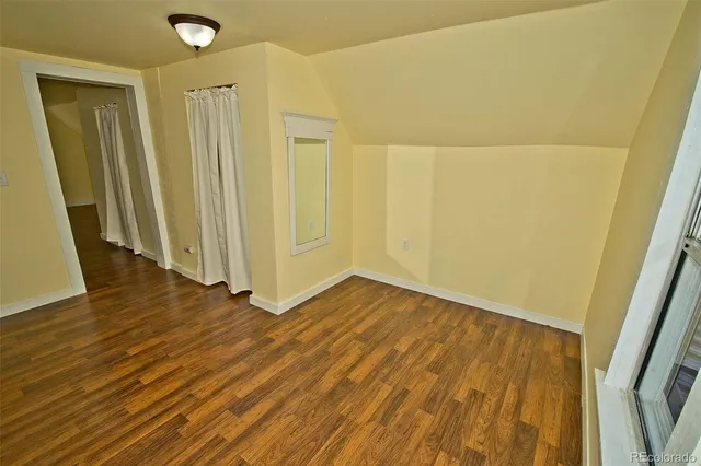 a view of a room with wooden floor and a hallway