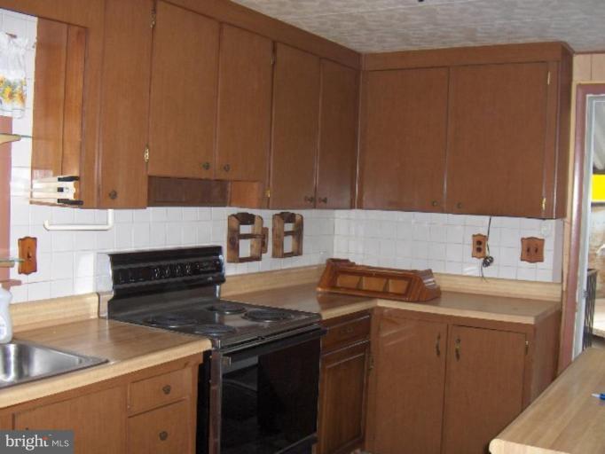 7922 Shore Road Sparrows Point, MD 21219 - Photo 4 of 8 a kitchen with a sink stove and cabinets