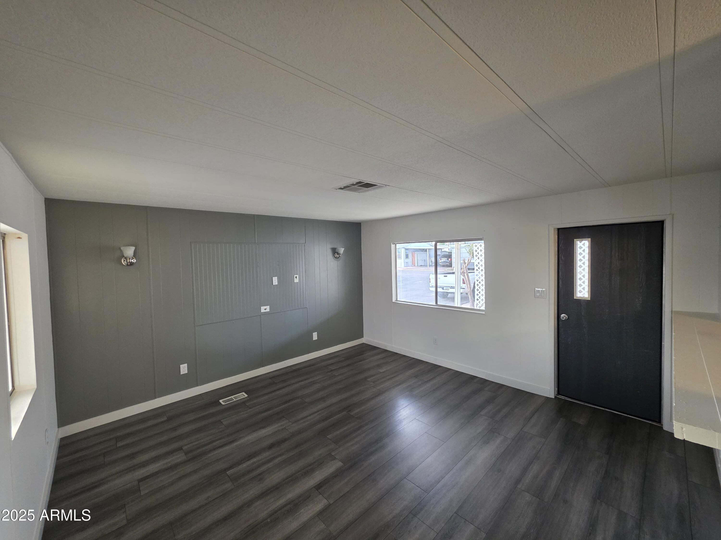 4800 West Ocotillo Road, Unit 105 Glendale, AZ 85301 - Photo 4 of 20 an empty room with wooden floor and windows