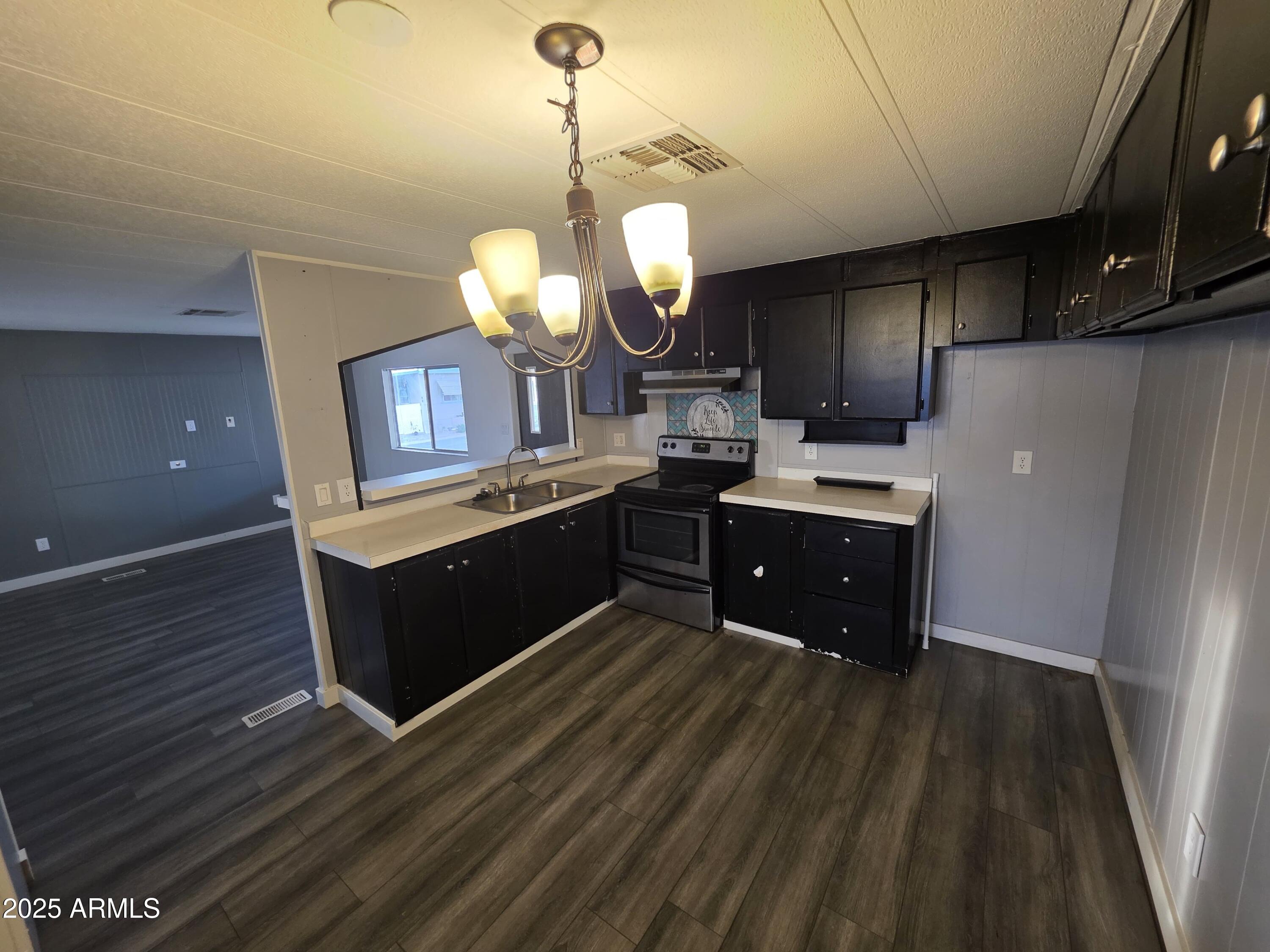 4800 West Ocotillo Road, Unit 105 Glendale, AZ 85301 - Photo 8 of 20 a kitchen with granite countertop a sink cabinets and stainless steel appliances