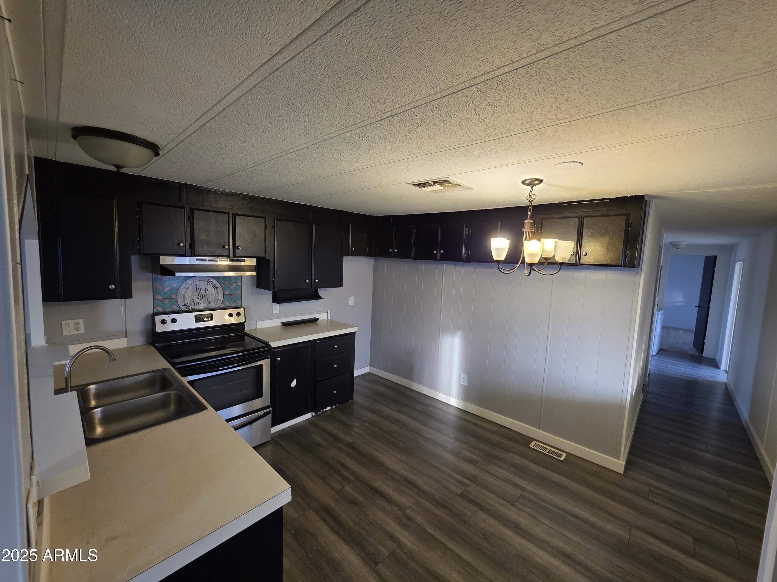 4800 West Ocotillo Road, Unit 105 Glendale, AZ 85301 - Photo 9 of 20 a kitchen with wooden floors and stainless steel appliances