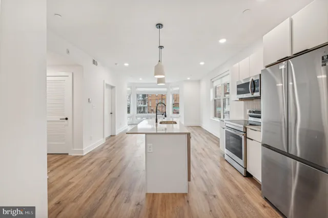 a kitchen with granite countertop a sink stove and refrigerator