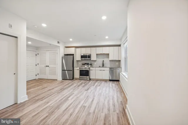 a kitchen with cabinets stainless steel appliances a sink and a window